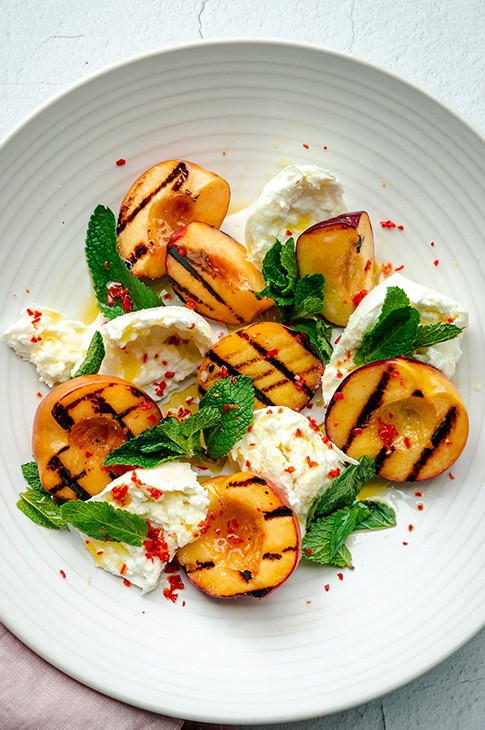 Grilling fruit on the BBQ is less common than vegetables and yet it's so delicious! Here is a recipe for grilled peaches served with mozzarrella di bufala cheese, fresh mint, a drizzle of olive oil and a little crushed chili...it's the perfect starter for a summer evening!