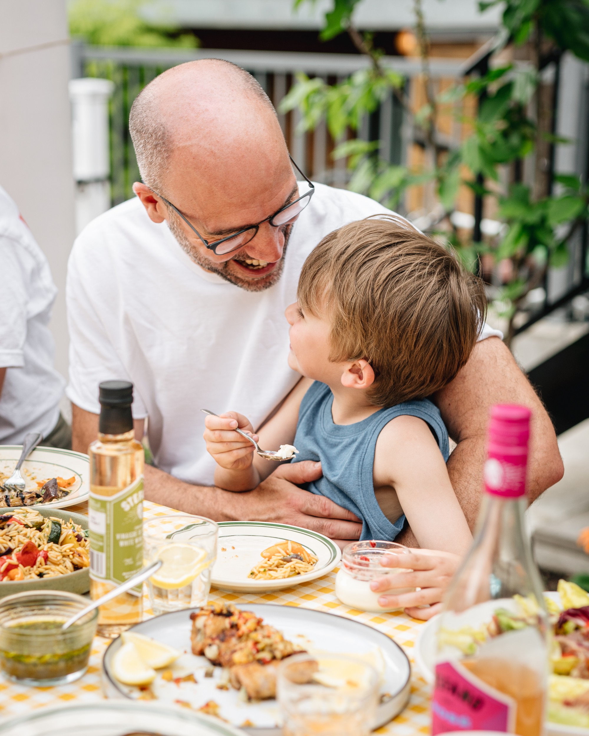 Stefano Faita et son fils, Dario, assis à une table de pique-nique, souriants.