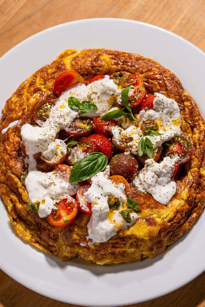 Ici, on vous propose une version rutilante de la frittata qui se prépare à l’année, mais qui prend tout son sens quand on a la chance d’avoir accès à de belles tomates locales d’été. Elle s’inspire de la célèbre salade caprese qui met de l’avant la Sainte Trinité des produits italiens : tomates, mozzarella et basilic. C’est frais, c’est gourmand. C’est facile, c’est élégant. C’est à essayer absolument!