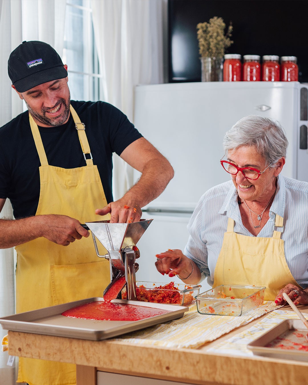 Deux personnes préparent de la sauce tomate